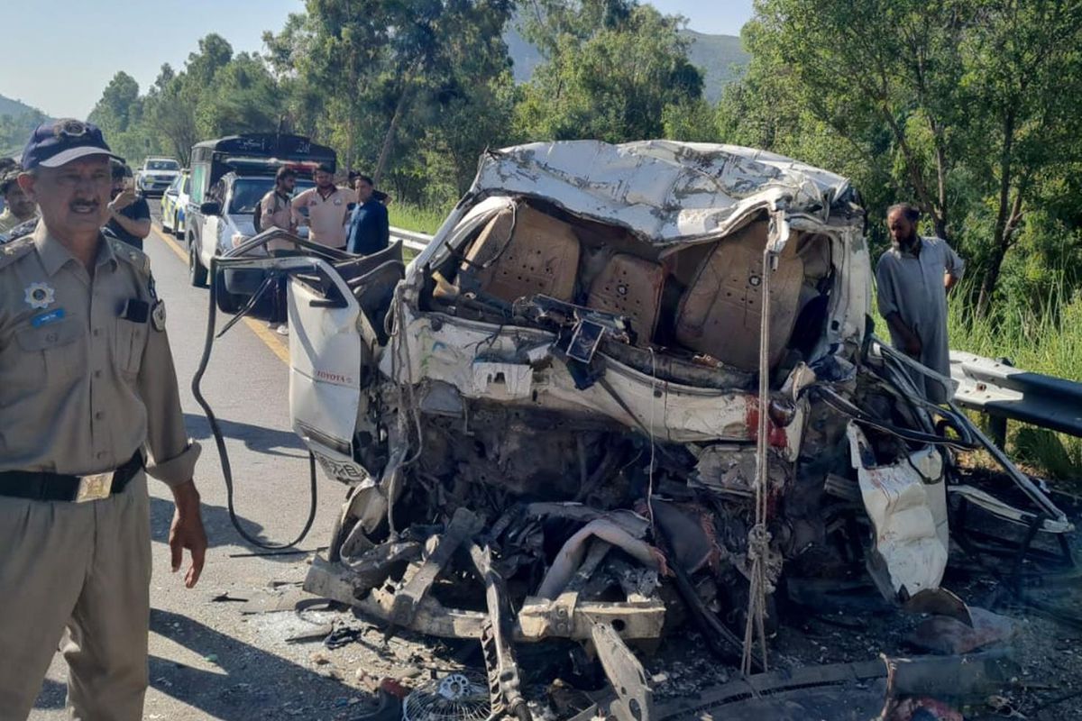 Pakistan’da kaza sonrası hasar gören minibüs ve otobüsün bulunduğu yol bölgesi