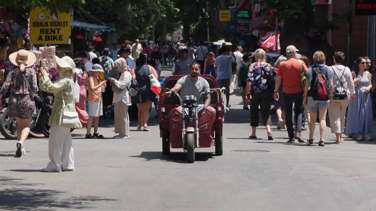 Hafta sonunda Büyükada sahilinde ve çarşı bölgesinde yürüyen ziyaretçiler